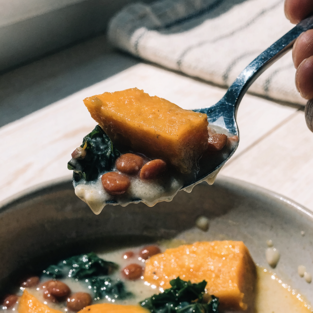 Close-up of ginger sweet potato and coconut stew with lentils & kale